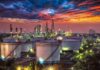 Oil refinery with storage tanks at sunset