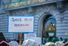 Sign reading Save Our Healthcare at protest.