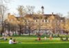Anonymous Trolls Ignite Georgetown Firestorm Students relaxing on a campus quad in front of a brick academic building