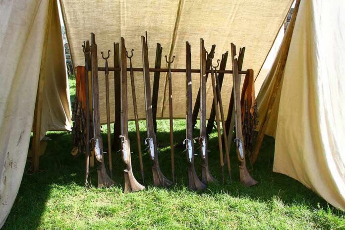 shutterstock_1042738783 Rack of antique muskets inside a canvas tent