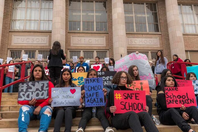 Students holding protest signs on school steps