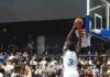 Basketball player dunks the ball in a crowded arena