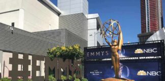 Emmy Awards outdoor setup with large statue and blue carpet