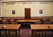 Empty courtroom with wooden tables and gallery seating