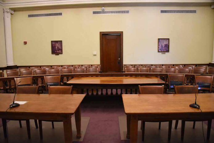 Empty courtroom with wooden tables and gallery seating