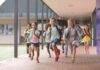 Group of schoolchildren running down a hallway