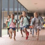 Group of schoolchildren running down a hallway