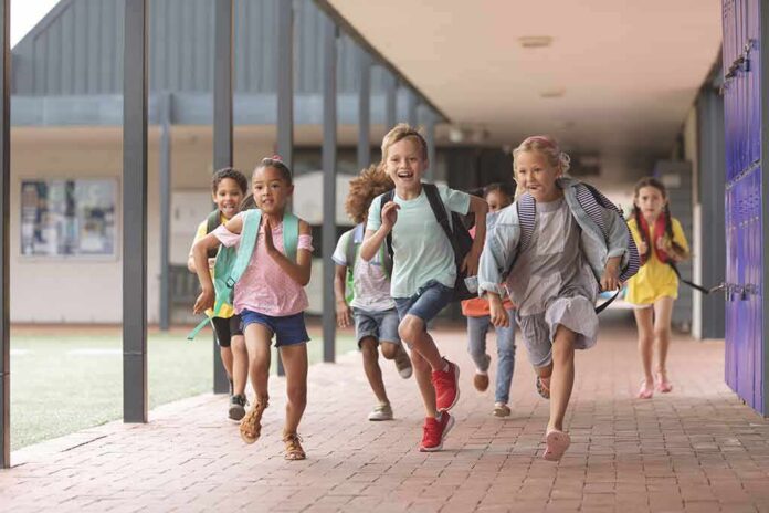 shutterstock_1352249762-16 Group of schoolchildren running down a hallway