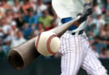 Baseball player hitting a ball with a wooden bat