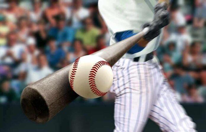 Baseball player hitting a ball with a wooden bat