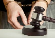 Handcuffed person behind judge's gavel
