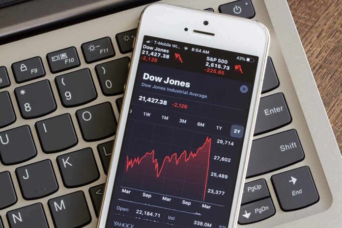Smartphone showing Dow Jones chart on a laptop keyboard