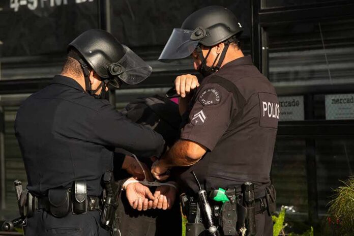 Police officers handcuff a person during an arrest