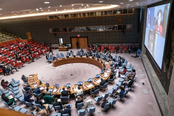 Delegates seated around a circular conference table in a large chamber