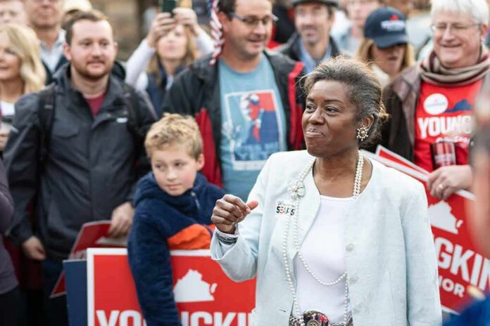 Woman speaking at a public rally surrounded by supporters