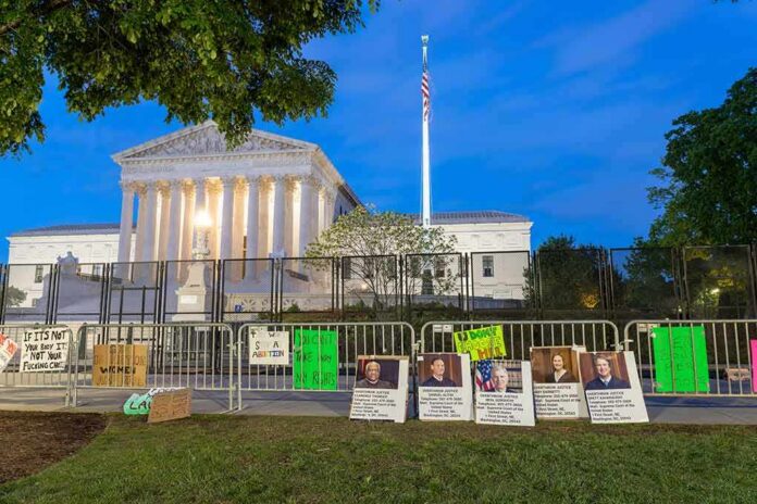 Supreme Court building behind fences and protest signs at dusk