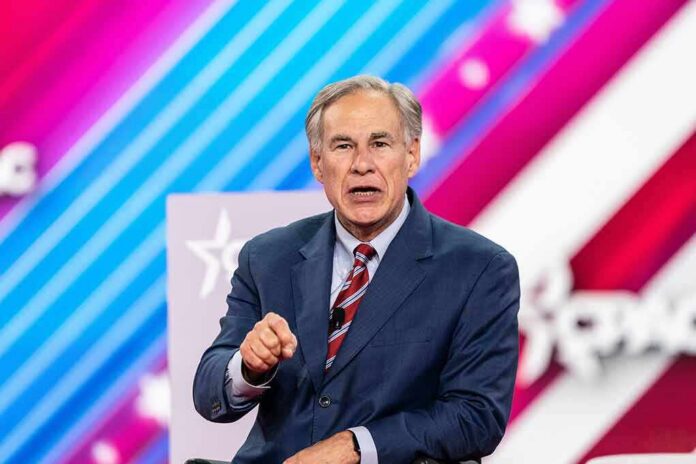 Greg Abbott speaking on stage in a suit against a colorful striped backdrop