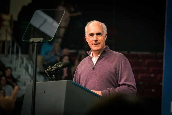 shutterstock_2231122653 Bob P. Casey, Jr. speaking at a podium with microphones and teleprompter
