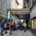 Andreas Hestler and pedestrians outside The Roosevelt Hotel entrance on a city sidewalk