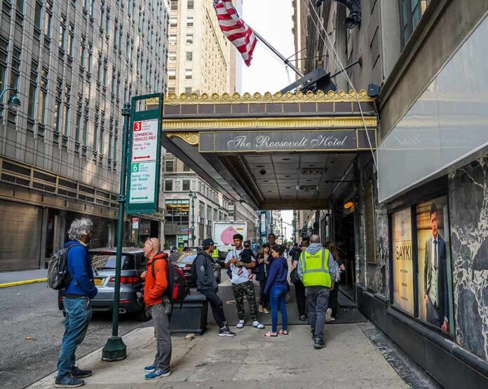 Andreas Hestler and pedestrians outside The Roosevelt Hotel entrance on a city sidewalk