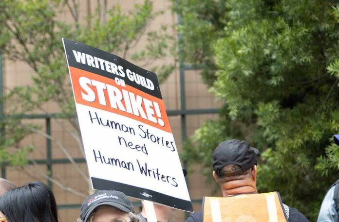 Protesters holding a strike sign at an outdoor rally