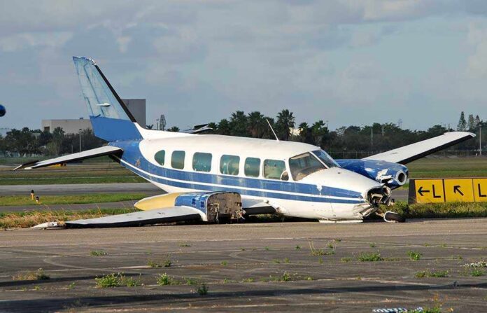 Damaged blue and white small airplane on an airport runway