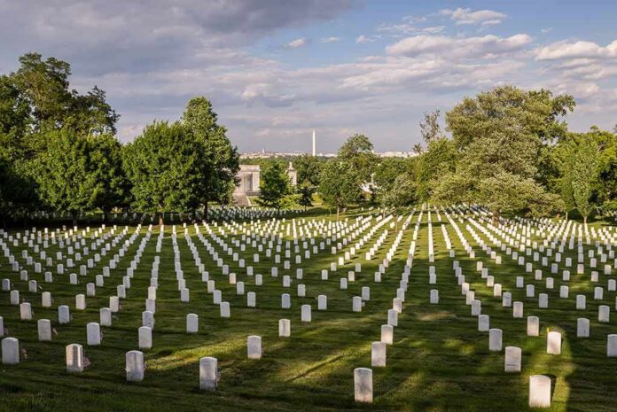 shutterstock_295252223-8 Rows of white headstones in a cemetery under a partly cloudy sky