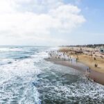 Crowded sandy beach with people by the shoreline