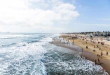 Crowded sandy beach with people by the shoreline