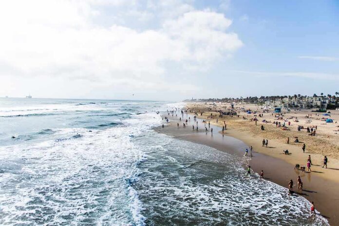 Crowded sandy beach with people by the shoreline