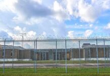 Prison yard behind chain-link and razor wire fence