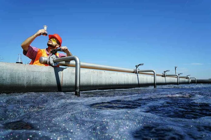 Engineer inspecting water sample at wastewater treatment plant