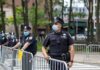 Walter Jones, a police officer in a face mask standing by metal barricades