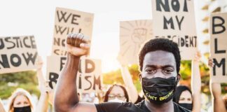 Protester wearing mask raises fist during demonstration