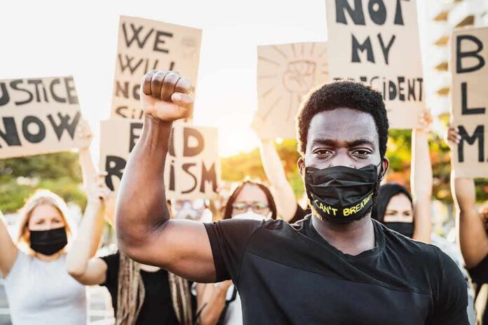Protester wearing mask raises fist during demonstration