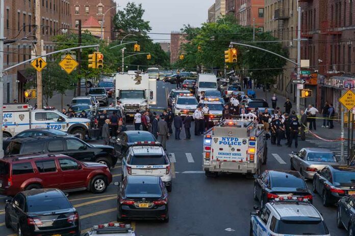 Police vehicles and officers block a city street during an active scene
