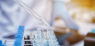 Pipette dispensing liquid into test tubes in a laboratory rack