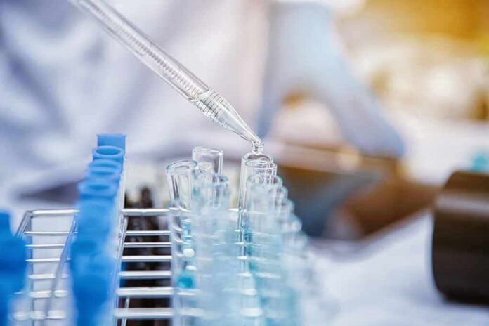 Pipette dispensing liquid into test tubes in a laboratory rack
