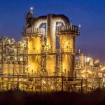 An industrial facility with illuminated structures at night