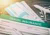 Travel insurance form with boarding passes and toy airplane
