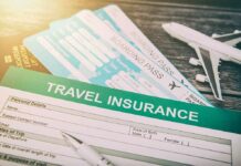 Travel insurance form with boarding passes and toy airplane