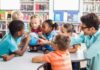 Children and teacher gathered around a small globe in a library