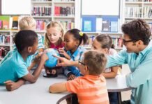 Children and teacher gathered around a small globe in a library