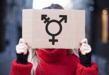 Person holding cardboard sign with gender symbol
